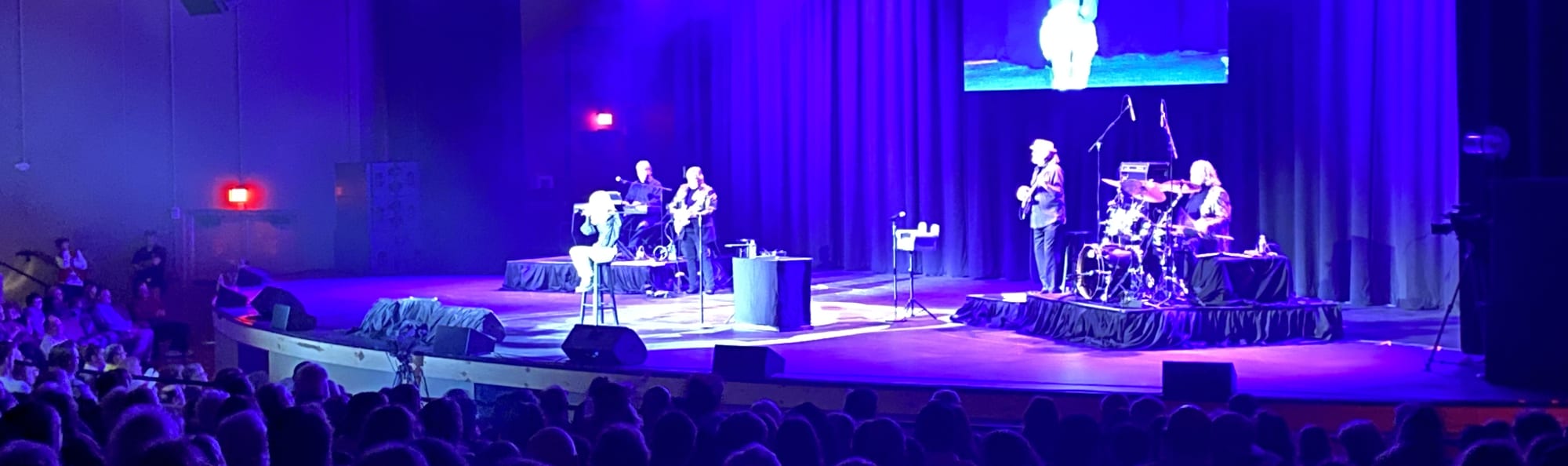 signer on stage in chair washed out by the lights Asheville